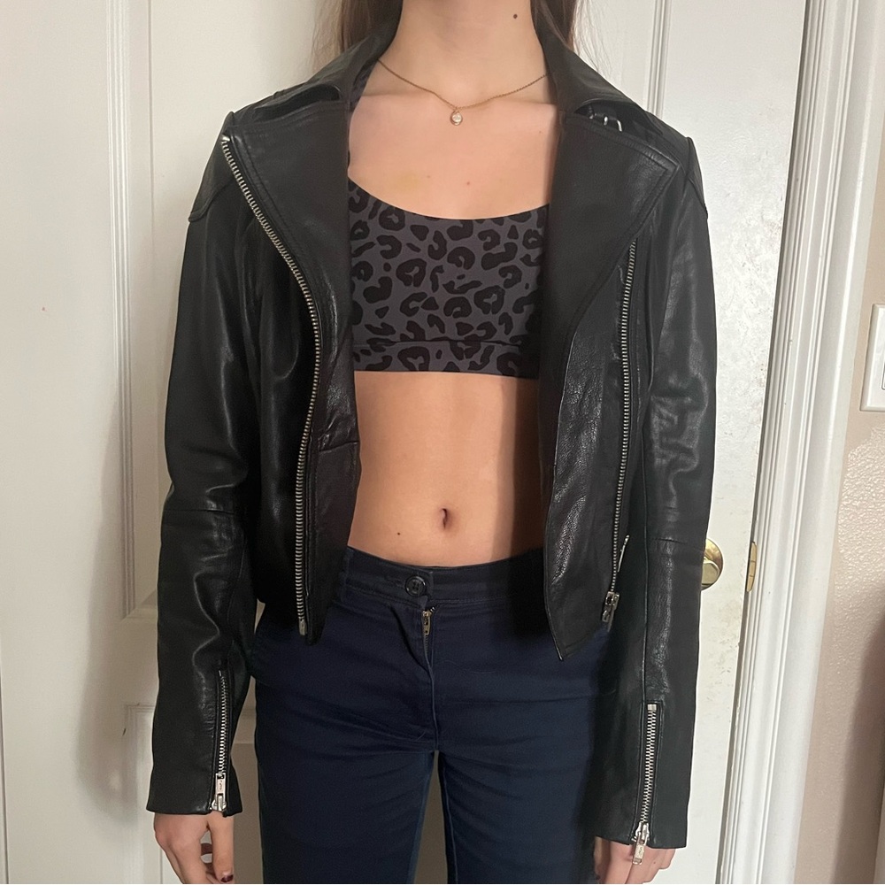 cropped black leather jacket with studded peace sign on the back